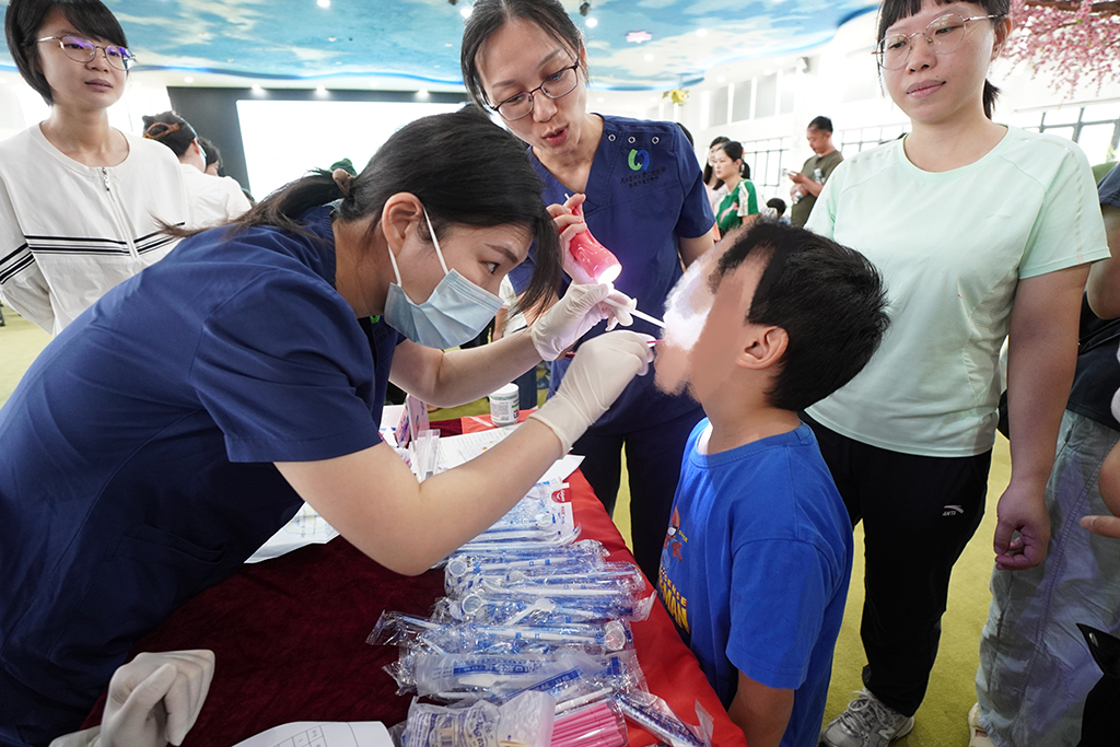 图为专家医护人员为中心儿童进行口腔健康检查.jpg